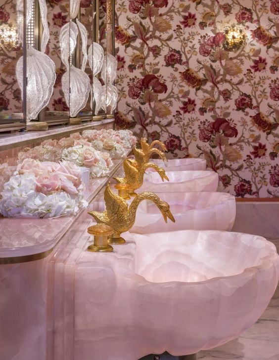 Дизайн туалета с розовыми мраморными раковинами и смесителями лебедями