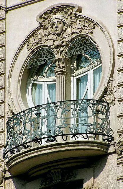 круглое окно с маскароном и кованый балкон