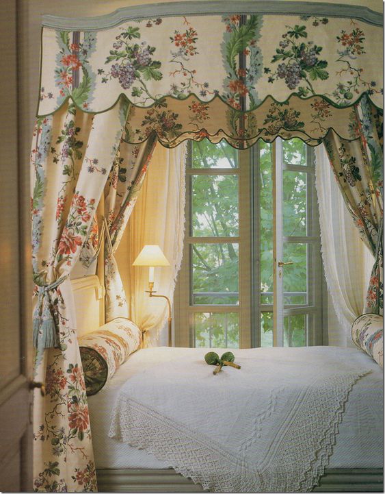 Интерьер спальни с французским окном бежевым балдахином с крупным цветным рисунком