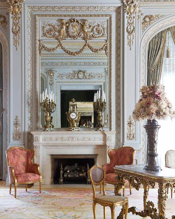 Камин с зеркалом в интерьере гостиной и золотым декором